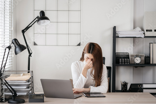 Stress businesswoman is sitting at table  under stress from working.