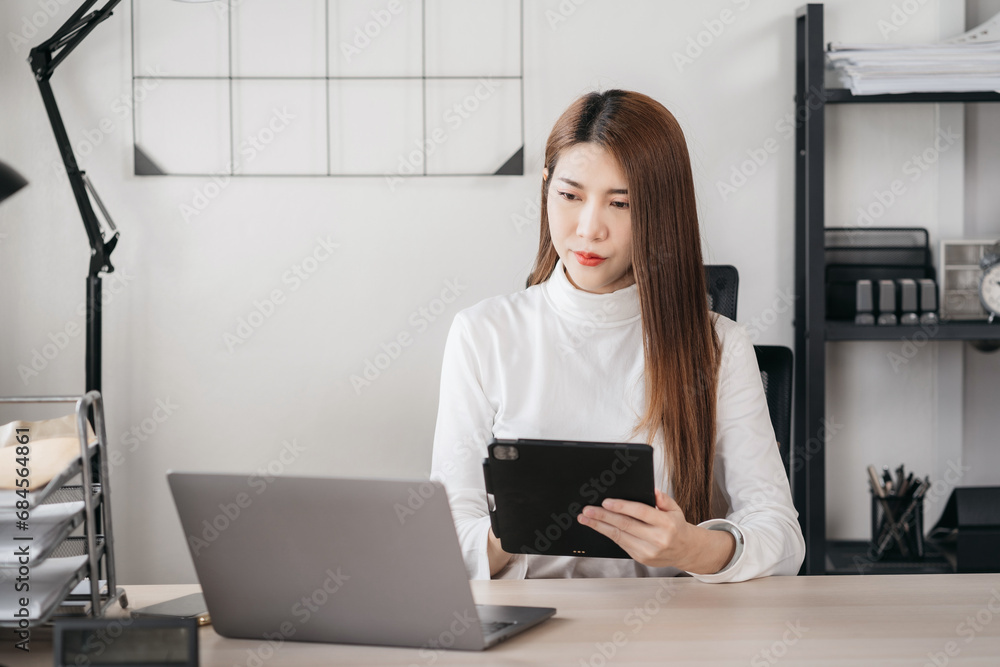 Business woman using smartphone and laptop computer in office. Happy woman, entrepreneur, small business owner working online. Business woman using smartphone and laptop computer in office. Happy woman, entrepreneur, small business owner working online.