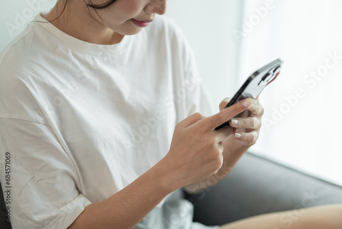 Asian woman using smart phone spending time checking news social media cell telephone technology e-commerce