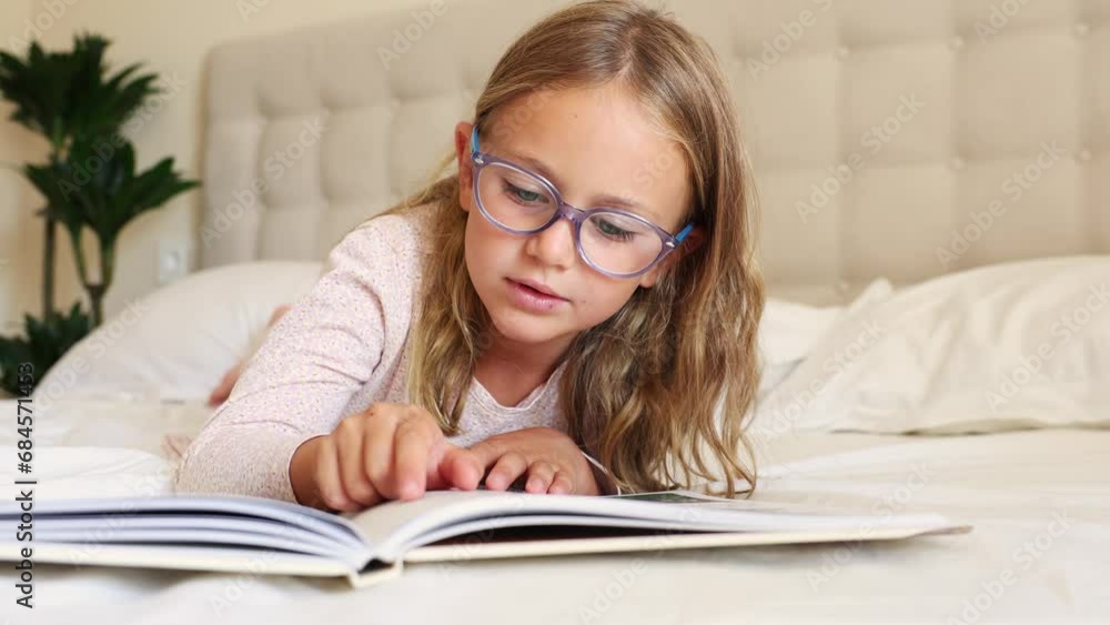 A child girl with reading eyeglasses reads book. Early literacy tip. Swipe under the words. Toddler develops skills. Children eyes myopia,nearsightedness, hyperopia,farsightedness,astigmatism A child girl with reading eyeglasses reads book. Early literacy tip. Swipe under the words. Toddler develops skills. Children eyes myopia,nearsightedness, hyperopia,farsightedness,astigmatism