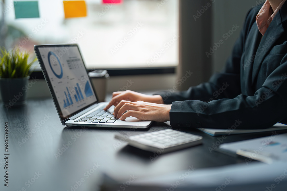 Young business woman looking at computer monitor, analyzing project statistics, marketing research results or statistics data, developing marketing strategy, working at office Young business woman looking at computer monitor, analyzing project statistics, marketing research results or statistics data, developing marketing strategy, working at office