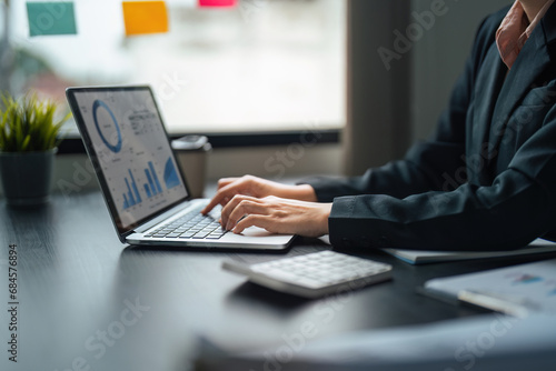 Young business woman looking at computer monitor, analyzing project statistics, marketing research results or statistics data, developing marketing strategy, working at office