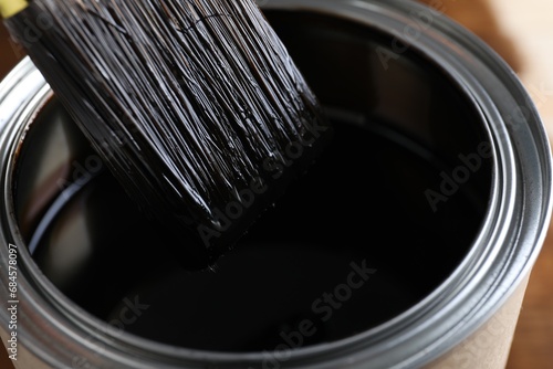 Dipping brush into can with wood stain, closeup