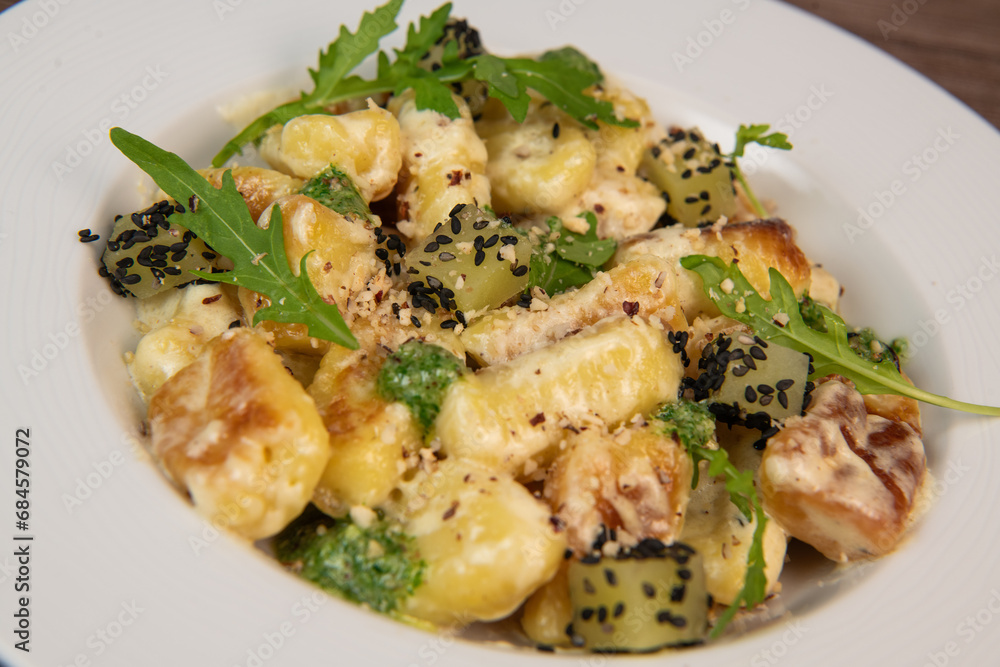 RECIPE FOR POTATO GNOCCHI WITH ROCKET SALAD PESTO AND CREAMY PARMESAN SAUCE. High quality photo RECIPE FOR POTATO GNOCCHI WITH ROCKET SALAD PESTO AND CREAMY PARMESAN SAUCE. High quality photo