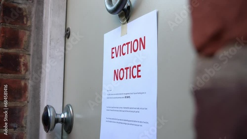 Low shot of eviction notice being placed onto door