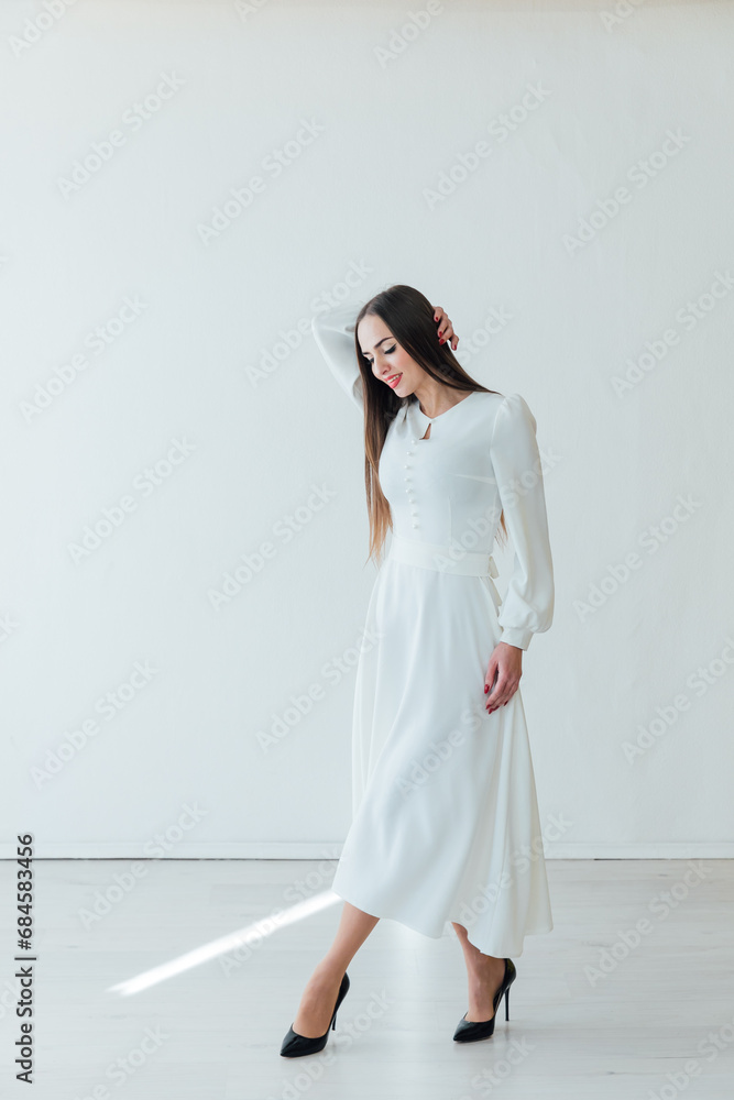 beautiful brunette woman posing on a white fashion background in a bright room beautiful brunette woman posing on a white fashion background in a bright room