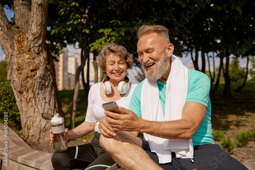 Happy overjoyed elderly man and woman couple enjoying sunny day after jogging