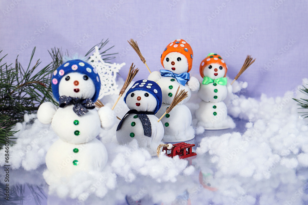 Christmas background: decorative snowmen on a pastel background, pine branches, bokeh, space for text Christmas background: decorative snowmen on a pastel background, pine branches, bokeh, space for text