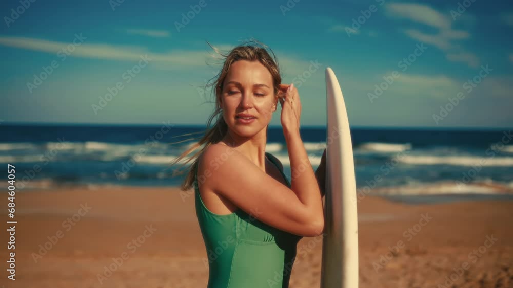 Beautiful caucasian woman in a swimsuit with a surfboard standing on a sandy beach near the sea. Sports and active recreation. Beautiful caucasian woman in a swimsuit with a surfboard standing on a sandy beach near the sea. Sports and active recreation.