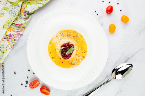 Ginger pumpkin soup with dumplings and berries. White background top view
