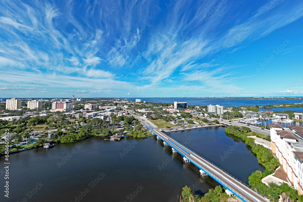 Fototapeta premium Aerial view of the newly built train tracks over Crane Creek leading to the Indian River and yacht harbor in historic downtown Melbourne along Florida's Space Coast in Brevard County
