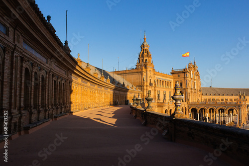 Seville, Spain, September 11, 2021: The Spanish Steps in Seville or 'Plaza de España', where the main building of the Ibero-American Exhibition of 1929 was built. Spanish flag at sunset.