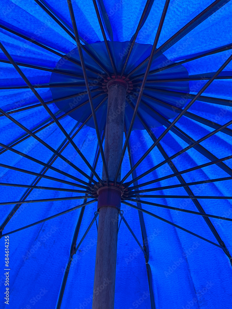 Fototapeta premium blue umbrella on the background of the sun.
