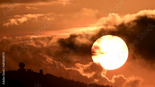 Spectacular close-up of the sunset process. Orange flaming sky. In the foreground is the Wufenshan weather radar station. Ruifang, Taiwan. photo