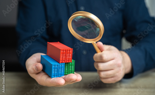 Examining cargo containers through a magnifying glass. Countering smuggling. Sanctioned goods. Prohibited products entering sanctioned countries through transit. Bypassing sanctions. photo