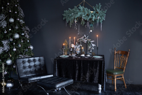 New Year's dark interior, Christmas tree with New Year's decorations and a decorated table in a dark style