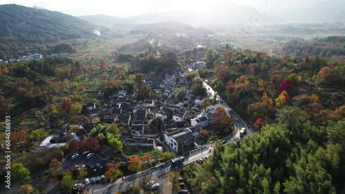 Aerial view of Chinese ancient village, Tachuan, Hongcun, Anhui, China. Drone fly view of traditional villages in sunny autumn day with flying upwards shot, 4k real time footage. photo