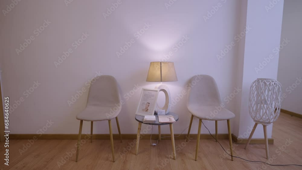 Camera shows chairs and a small table with a lamp Camera shows chairs and a small table with a lamp