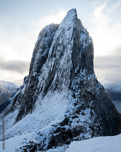 Aerial drone photo of snowy mountain hike up Segla in Senja, Norway. Snowcapped mountains in the Arctic Circle of Northern Norway. Famous hike on Senja island. Shot in October