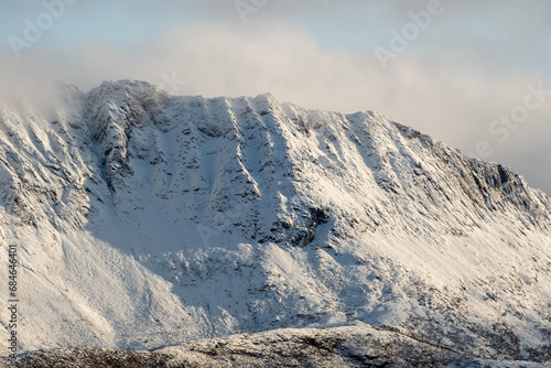 Snowy mountain hike up Segla in Senja, Norway. Snowcapped mountains in the Arctic Circle of Northern Norway. Famous hike on Senja island. Shot in October