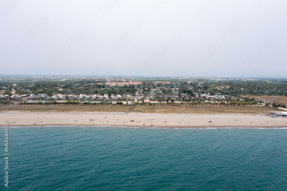Aerial view of beachside town with lush landscape.