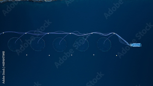 An aerial top down of a Norwegian Fish Cage.  Located in the arctic circle of northern Norway. Shot on drone.