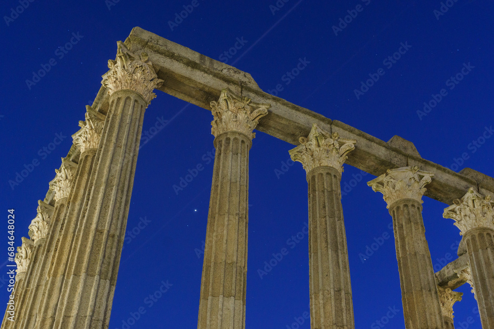 Columns of ruins of ancient roman temple of Diana during evening twilight with planets Jupiter and Saturn on the blue sky, Evora, Alentejo, Portugal
