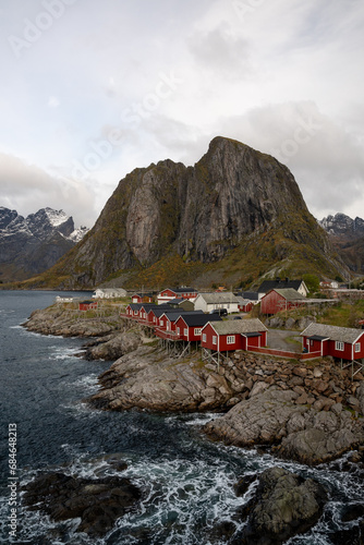 Aerial of the village Reine and Hamnoy in Lofoten, Norway. Shot on a drone located in the Arctic circle. An entire small fishing village with red houses along the Arctic ocean.
