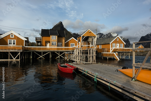 The fishing village of Hamnoy in Lofoten  Norway.  Image shot on a mirrorless camera located in the Arctic circle.  An entire small fishing villlage with yellow houses along the Arctic ocean.