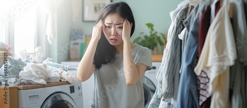 Asian woman with unpleasant expression after doing laundry due to dirty and musty smelling clothes copy space image photo