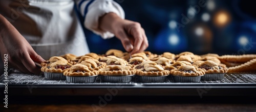 Chef s hands fill a small pie Raw baked goods rest on a metal baking sheet in a bakery Pie and flour products made copy space image