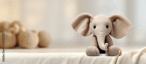Baby elephant plush toy on white blanket with burlap copy space image