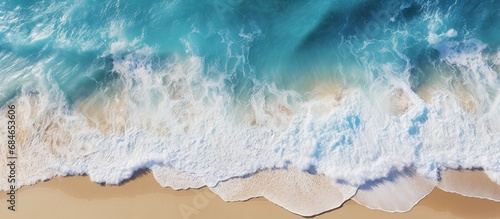 A clear day beach with crashing waves seen from above copy space image