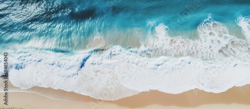 A clear day beach with crashing waves seen from above copy space image