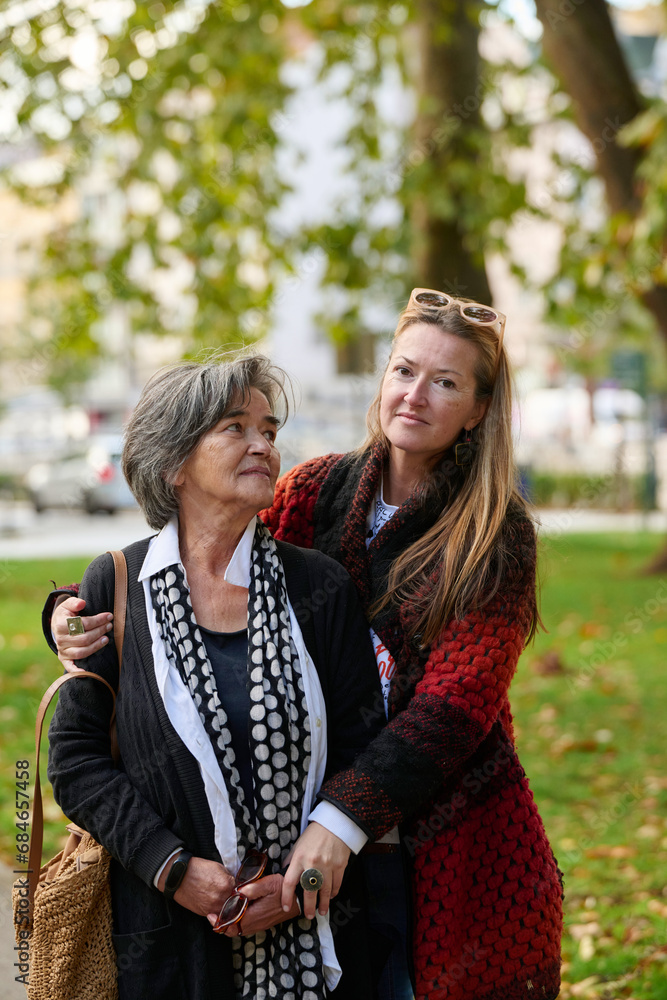 Fototapeta premium Elderly old cute woman with Alzheimer's very happy and smiling when eldest daughter hugs and takes care of her 