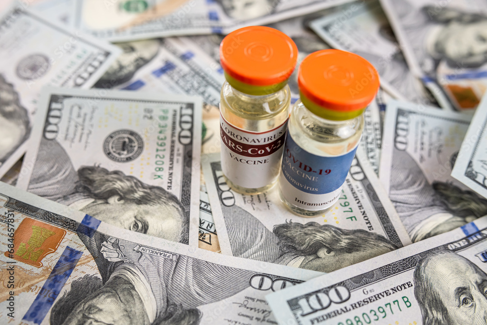 Fototapeta premium COVID-19 or other vaccine in bottle on dollar bills background