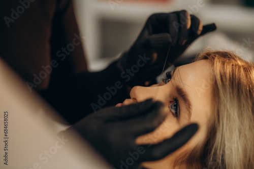 Mikrobleiding eyebrow measurement. Cosmetologist makes markings with pencil and threads for perfect shaped eyebrows. Professional makeup and facial care. Permanent makeup, tattooing of eyebrows. photo