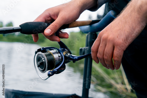 Quadro su tela close-up Fly fisherman male hands with fishing rod or spinning in hands feeder f