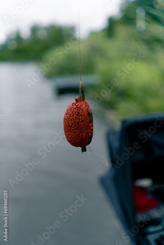 close-up fishing edible bait hanging on a hook on the background of the river nature sport fishing feeder free style method