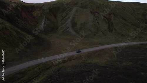 DRONE AERIAL FOOTAGE: Car driving off-road terrain exploring the Fjallabak Natural Reserve. A 4x4 car driving dirt road traveling in Iceland sightseeing wilderness. photo