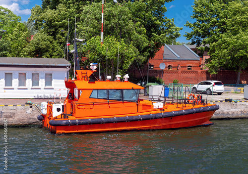 Swinoujscie. A red pilot boat moored at the pier on a sunny day. photo