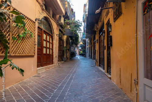 Chania Old Town Crete island Greece. Narrow empty paved street, multicolor shop, flower, summer day.