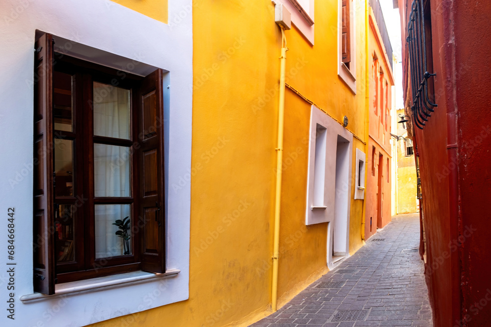 Traditional narrow paved alley between multicolor building. Chania Old Town, Crete island, Greece.