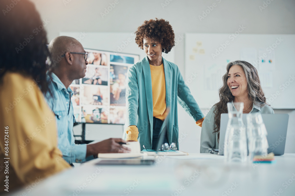 Smiling businesswoman talking with coworkers during an office meeting Smiling businesswoman talking with coworkers during an office meeting