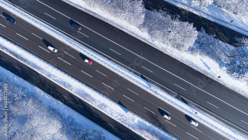 Aerial top view of snow covered Autobahn highway in the south of Munich surrounded by forest in winter photo