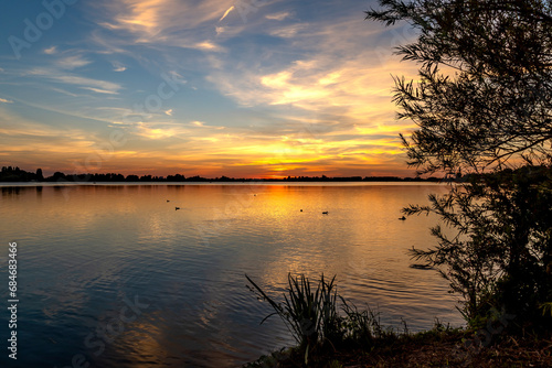 View of a beautiful sunset from the shore of lake Zoetermeerse Plas, Netherlands photo