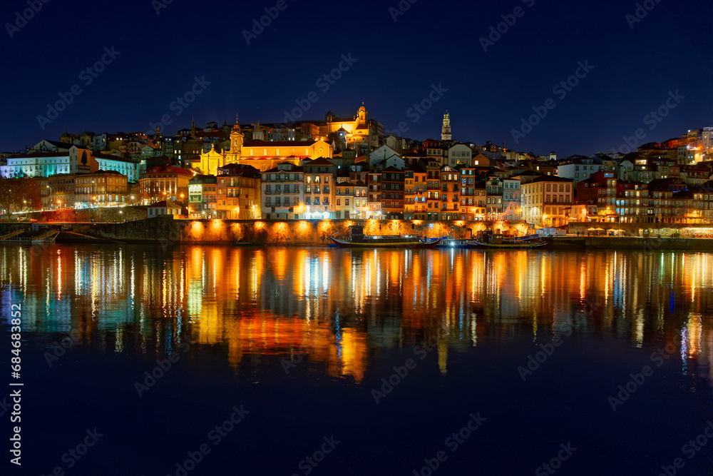 Porto, Portugal old city skyline from across the Douro River at night.