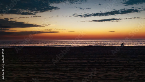 A lone person has arrived before sunrise to make sure they don't miss the Spectacular light show that is about to happen. Sunrise over the Atlantic Ocean at Ocean City MD in late October