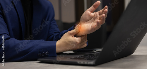 close up businessman massage on hand palm while feel stiffness after hard working to relief pain or cramp or carpal tunnel for office syndrome and health lifestyle concept photo