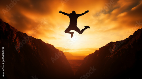 Silhouette of a man jumping on the edge of a cliff